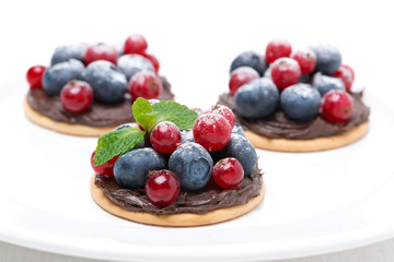 mini cakes with chocolate cream and berries on the plate