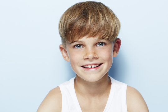 Portrait of young boy in vest, studio.