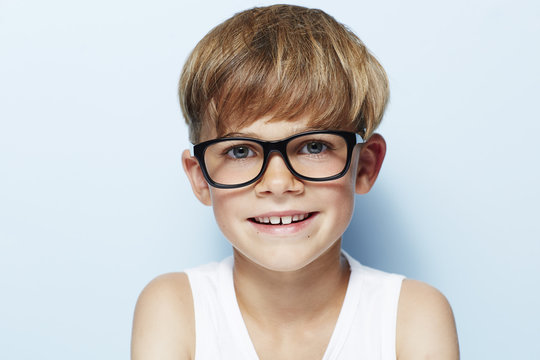Portrait of young boy wearing glasses, studio.