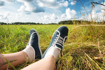 Feet at field with beautiful clouds