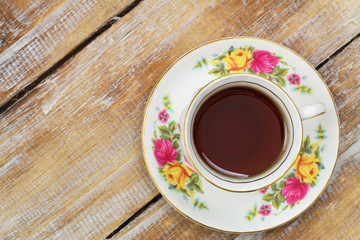 Tea in vintage cup on wooden surface