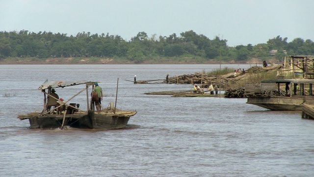 Barge moving towards the riverside work site for prefabrication of bamboo-based components to be used in bridge construction
