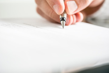 Man writing on a document with a fountain pen