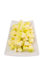 Bite sized honeydew pieces on white plate