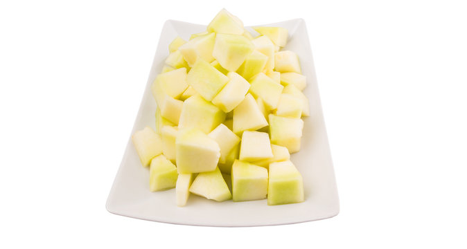 Bite sized honeydew pieces on white plate