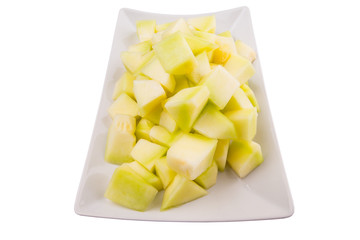 Bite sized honeydew pieces on white plate