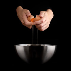 Hands breaking an egg.