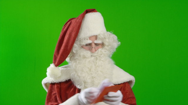 Santa Claus is reading a wish list and begins to laugh