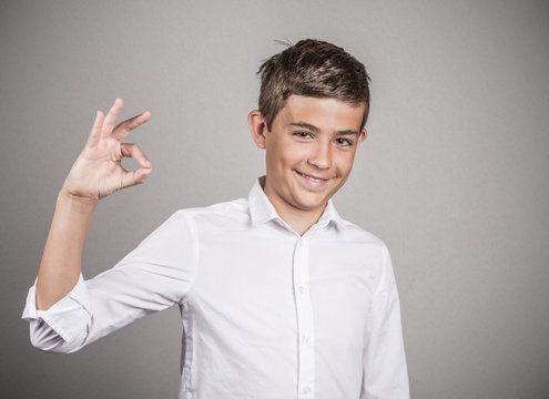 Happy teenager showing Ok sign isolated grey background 
