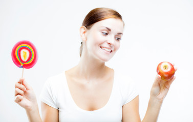 Woman choosing between sweets and fruits