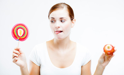 Woman choosing between sweets and fruits