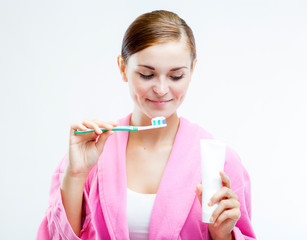 Woman with toothbrush and tooth paste tube