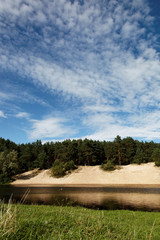 Landscape - meadow, blue sky and river.