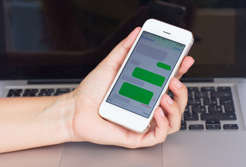 hand holding smartphone with sms clouds