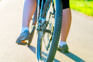Naklejka premium bicycle wheel and foot girl close-up