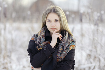 Beautiful Russian woman in a scarf in winter