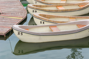 Numbered pleasure rowing boats tied up on a lake