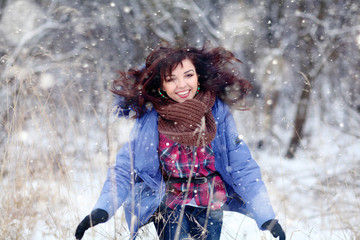 Fototapeta na wymiar Girl having fun and jumping in the snow