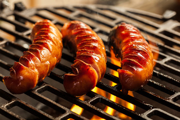 Grilling sausages on barbecue grill