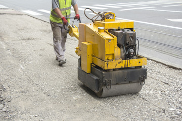 Worker use Vibration roller compactor on repair pavement - obrazy, fototapety, plakaty