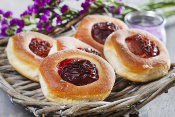Round buns with plum on wooden table