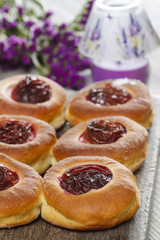 Round buns with plum on wooden table