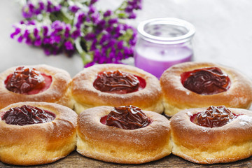 Round buns with plum on wooden table