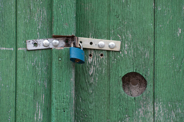 Green wooden door and blue lock