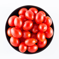 cherry tomatoes in a black bowl isolated on white
