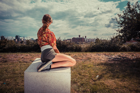Young woman sitting outside and looking at city