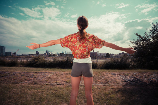 Young woman raising her arms and admiring the view