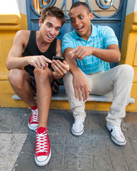 Young males having fun with a cellphone.