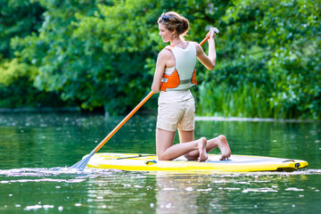 Frau beim Stehpaddeln Sup auf Fluss 