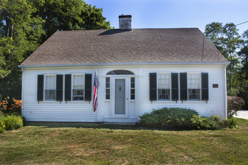 White Cape Cod house with green shutters Massachusetts