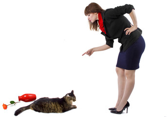 woman scolding pet cat that toppled a flower vase