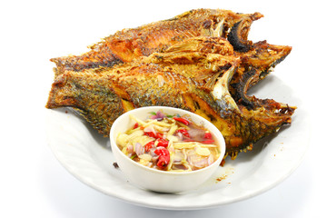 fried nile tilapia fish with mango sauce on white plate isolate 
