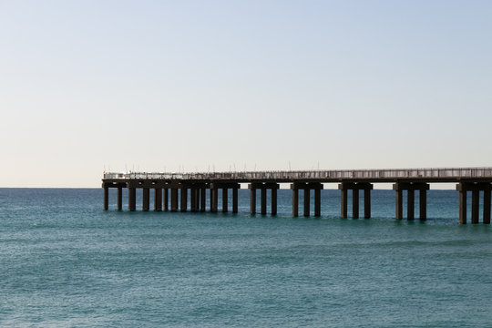 Ocean fishing pier stretchs over calm seas