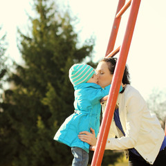  mother doing fitness with little daughter at the playground