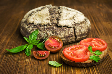 sandwich with rye bread, tomato and basil