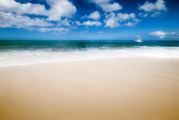 Fototapeta na wymiar Beach and sea with a boat in the horizon