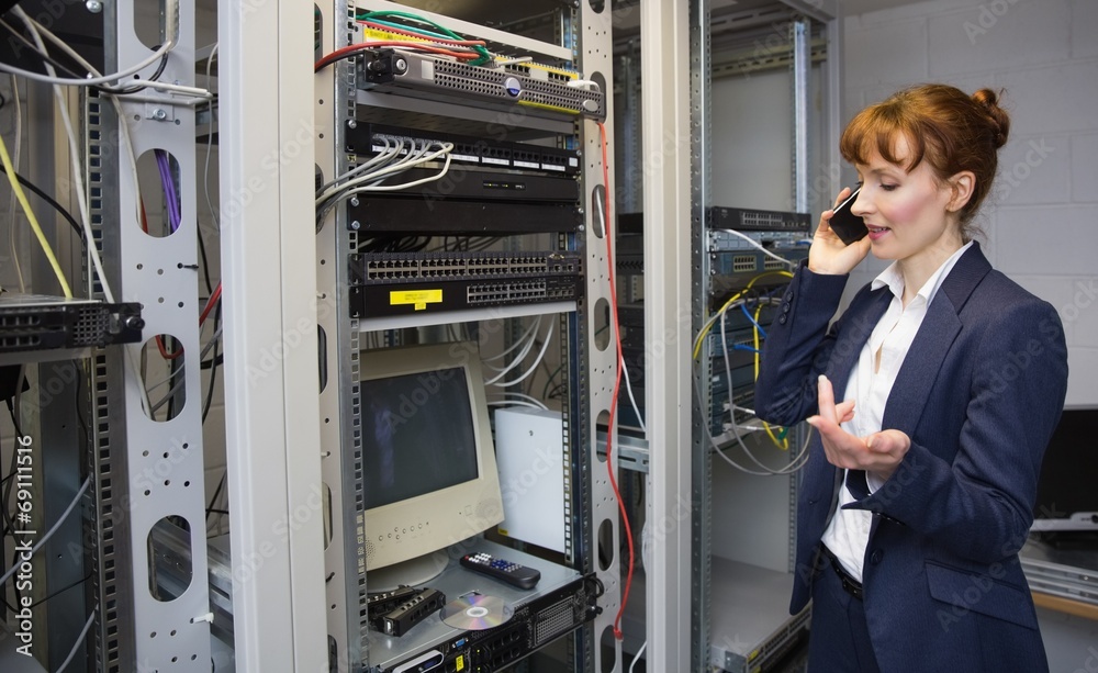 Aufkleber Pretty computer technician talking on phone beside open server