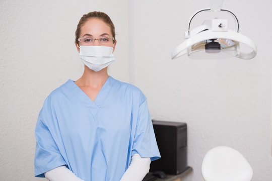 Dentist In Blue Scrubs Looking At Camera In Mask