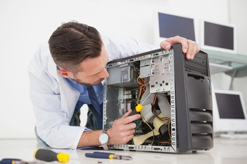Computer engineer working on broken console with screwdriver