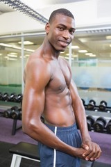 Fototapeta na wymiar Shirtless young muscular man posing in gym