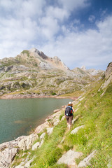 Woman walking in the spanish pyrenees by Estanes lake during sun