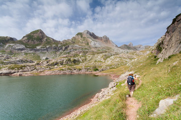 Woman walking in the spanish pyrenees by Estanes lake during sun