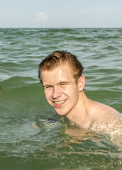 teenage boy enjoys swimming in the ocean