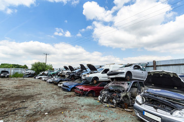 Lots of destroyed cars in a row at scrapyard
