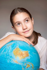 Back to school. Dreaming smiling girl with blue globe. Childhood