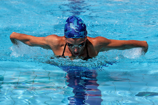 Woman swimming in butterfly style in pool